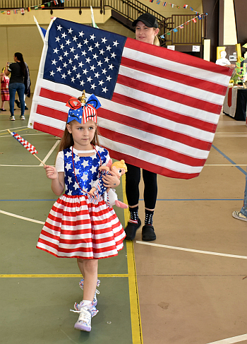 Aubrey Acquarulo, 6, represents the United States in the Parade of Flags during St. David School's cultural festival Feb. 5. Holding the American flag is her mother, Jessi.