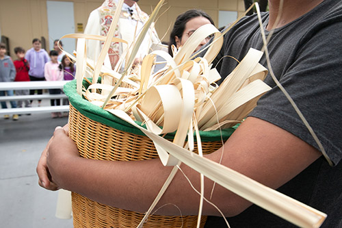 En esta foto de archivo, un estudiante del programa de educación religiosa en la iglesia St. Matthew, en Hallandale Beach, sostiene una canasta con las palmas del Domingo de Ramos del año pasado, que se quemarán y se convertirán en las cenizas del Miércoles de Ceniza de este año.