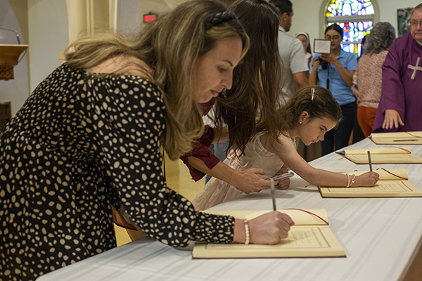 Catechumens sign the "Book of the Elect" during one of two Rite of Election ceremonies Feb. 26, 2023 at St. Mary Cathedral.