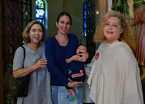 Blanca Salas, Mater Filius director, left, poses with Leyannis Rodriguez, a catechumen who was helped by the group, her 2-month-old son, Aaron Rodriguez, and Zully Mar Vidal, her sponsor for the sacraments of initiation in the Catholic Church, which she will receive at the Easter Vigil at St. Mark Parish, Southwest Ranches. She was one of 453 catechumens Archbishop Thomas Wenski welcomed  as among the "elect" in the Catholic Church during two Rite of Election ceremonies held at St. Mary Cathedral the Sunday after Ash Wednesday, Feb. 26, 2023.