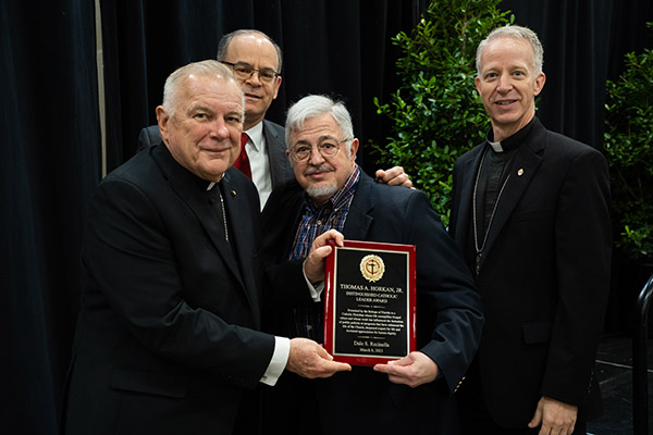 Archbishop Thomas Wenski of Miami presents the 2023 Distinguished Catholic Leader Award to Dale Recinella, as Michael B. Sheedy, Florida Conference of Catholic Bishops executive director, and Bishop William A. Wack CSC, of Pensacola-Tallahassee, look on.