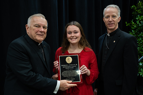 Archbishop Thomas Wenski of Miami presents the 2023 Distinguished Catholic Leader Award to Kiera Camron's daughter, Meredith Camron, as Bishop William A. Wack CSC, of Pensacola-Tallahassee, looks on.