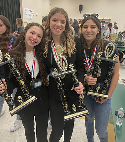 Eighth graders Carolina Nunez-Menocal, Anna Vieria, and Isabella Lopez from St. Hugh School in Miami pose with the trophies their group won for their model city, Imperium-Aqua, during the Future City regional contest in Tampa Bay in January 2023. The group qualified for the international contest in Washington, D.C. in February, where they placed fourth.