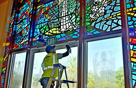 A Servpro worker cleans a doorjamb at St. Jerome Church, Fort Lauderdale, April 18, 2023, which was flooded during a rainstorm.