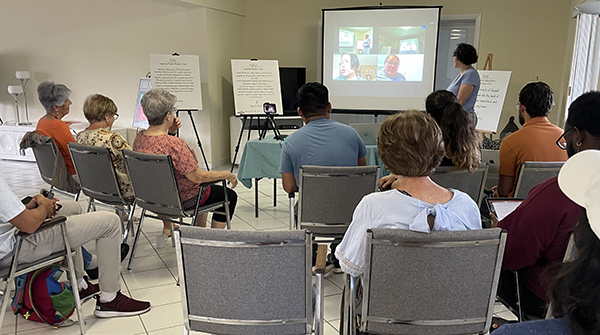 Los participantes se reúnen en el Centro Poveda de Miami, el 25 de marzo de 2023, para una presentación sobre Dreamers que incluyó presentaciones en persona y en línea.