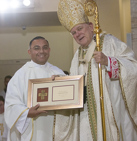 Father Fernando Carmona, currently serving as parochial vicar at St. Patrick Church, Miami Beach, is congratulated by Archbishop Thomas Wenski on his 25th anniversary in the priesthood, a recognition that took place during the chrism Mass at St. Mary Cathedral, April 4, 2023.