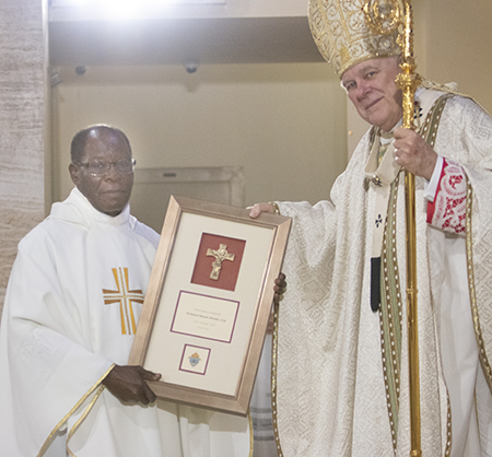 Spiritan Father Alexander Ekekchukwu, currently serving as pastor of Holy Redeemer Church, Liberty City, is congratulated by Archbishop Thomas Wenski on his 50th anniversary in the priesthood, a recognition that took place during the chrism Mass at St. Mary Cathedral, April 4, 2023.