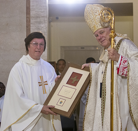 Father Paul Vuturo, who recently retired as pastor of St. Louis Parish in Pinecrest, is congratulated by Archbishop Thomas Wenski on his 50th anniversary in the priesthood, a recognition that took place during the chrism Mass at St. Mary Cathedral, April 4, 2023.