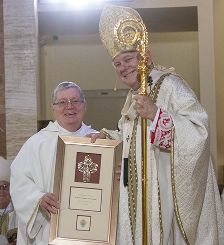Msgr. Jose Juan Quijano, retired professor at St. Vincent de Paul Regional Seminary in Boynton Beach, is congratulated by Archbishop Thomas Wenski on his 50th anniversary in the priesthood, a recognition that took place during the chrism Mass at St. Mary Cathedral, April 4, 2023.