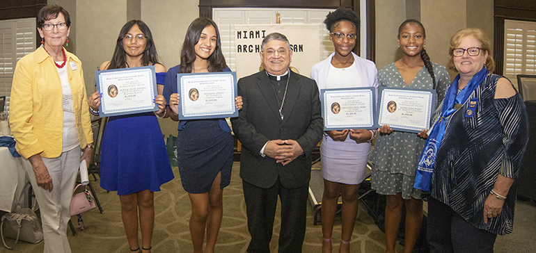 This year's recipients of the Lucy Petrillo Scholarship Award received $ 4,000 towards their Catholic high school tuition and fees. From left, Mary Weber, president of the scholarship committee, Ashley Elvir Lainez, from Our Lady Queen of Martyrs School, Milagros Funes, from St. Lawrence School, Auxiliary Bishop Enrique Delgado, Christine Bien-Aime, from St. James School, Sasha Jean-Felix, from St. Mary's Cathedral School, and Karen Lorenzen, president of the MACCW. Scholarships were given during  the 65th anniversary celebration of the Miami Archdiocesan Council of Catholic Women (MACCW) on April 29, 2023 in Fort Lauderdale.