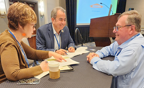 David Prada, center, senior director of the Office of Building and Property at the Archdiocese of Miami, and president of the board of directors for the Conference for Catholic Facility Management (CCFM), discusses a few points with colleagues during the group's 27th annual conference, held in Baltimore, Maryland, April 30-May 3, 2023.