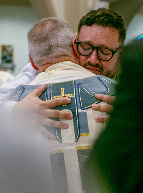 Newly ordained Father Sebastian Grisales shares an emotional embrace with Msgr. Pablo Navarro, rector of St. John Vianney Seminary in Miami, who vested him after his ordination. Msgr. Navarro also was his pastor at St. John Neumann in Miami for many years.