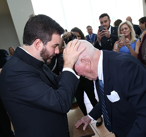 Father Andrew Vitrano-Farinato gives one of his first blessings to his grandfather, Deacon Vincent Farinato, after his ordination. He was one of five men ordained by Archbishop Thomas Wenski May 13, 2023, at St. Mary Cathedral.