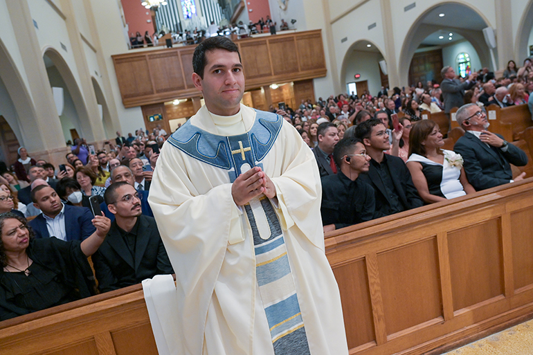 Newly ordained Father Gustavo Santos smiles at the camera after receiving his priestly vestments at the ceremony where Archbishop Thomas Wenski ordained him and four others to the priesthood for the Archdiocese of Miami, May 13, 2023, at St. Mary Cathedral.
