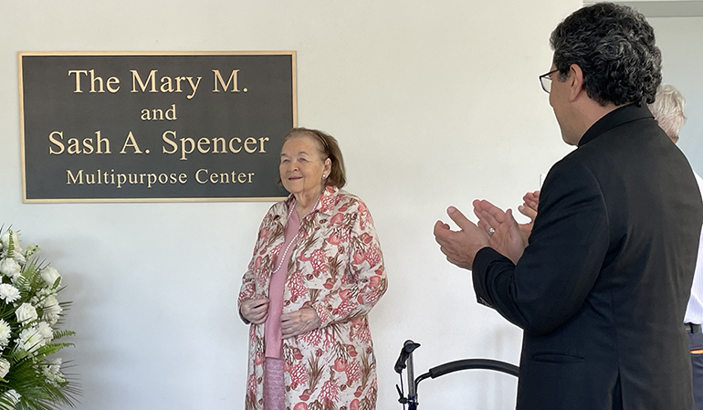 Father Juan Carlos Paguaga, pastor, applauds after Mary M. Spencer unveiled the plaque at the dedication of the new sports and multipurpose center at St. Agnes Parish in Key Biscayne, May 15, 2023.