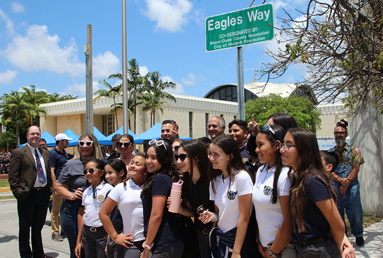 Fifth graders from St. John the Apostle School pose with teachers and city of Hialeah officials under the the new "Eagles Way" sign, named after their school's mascot and unveiled May 12, 2023.
