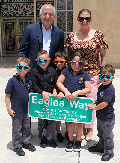 Mayor of Hialeah Esteban Bovo, Jr., and City of Hialeah Council President Vivian Cas&aacute;ls-Mu&ntilde;oz pose with PreK-4 students from St. John the Apostle School in Hialeah. On May 12, 2023, the city and the school celebrated the renaming of a nearby street to "Eagles Way" in honor of the school's mascot.