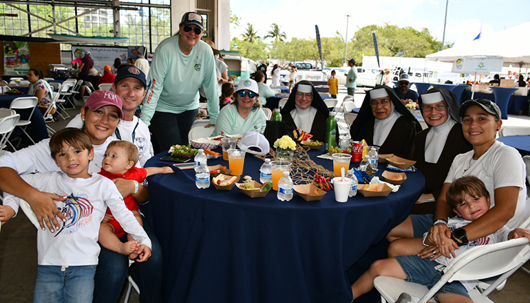 St. Theresa parents and students, joined by several Carmelite Sisters, enjoy music and food at the dock party that was part of St. Theresa School's 2023 Fishing Tournament, held May 20, 2023.