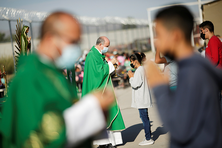 Priests distribute Communion during an outdoor Mass in celebration of the World Day of Migrants and Refugees at Casa del Migrante shelter in Ciudad Juarez, Mexico, Sept. 19, 2021. (OSV News photo/Jose Luis Gonzalez, Reuters)