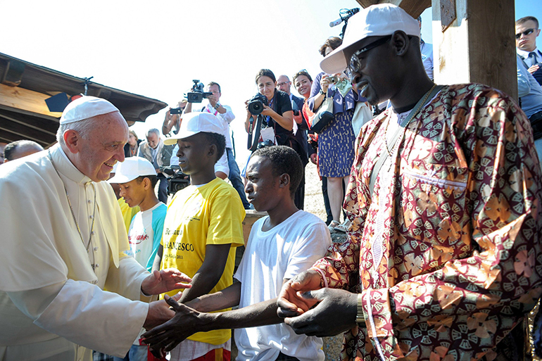 Pope Francis greets immigrants at the port in Lampedusa, Italy, in this file photo July 8, 2013. During his visit, the pontiff urged people not to be part of the "globalization of indifference" to the plight of the millions worldwide who are immigrants and refugees. (CNS photo/L'Osservatore Romano via CPP)