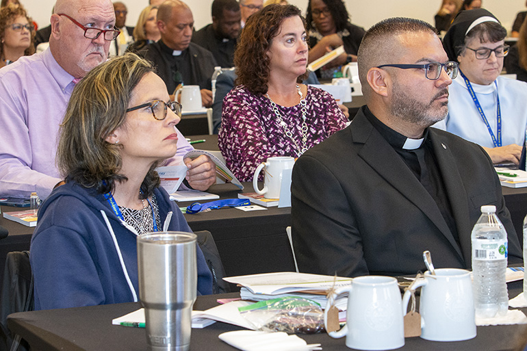 Pastors sit next to their elementary school principals during the all-principals meeting held before the start of the 2023-24 school year, Aug. 4, 2023, at St. Brendan High School. From left: Omayra Roy and Father Javier Barreto of Little Flower, Hollywood. Behind them are Thomas Halfaker of Our Lady of Lourdes elementary in Miami; Barbara Picazo of Our Lady of the Lakes, Miami Lakes; and Immaculate Heart of Mary Sister Carmen Fernandez of Our Lady of Lourdes Academy in Miami.