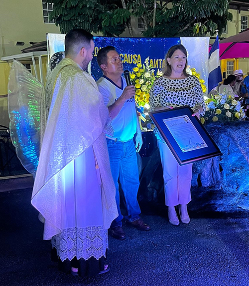 Alcides Membreno receives the document proclaiming Nicaraguan Day in  Hialeah from Councilwoman Vivian Casals-Muñoz, as Piarist Father Luis Alberto Cruz Baerga, pastor of St. John the Apostle Church, looks on.