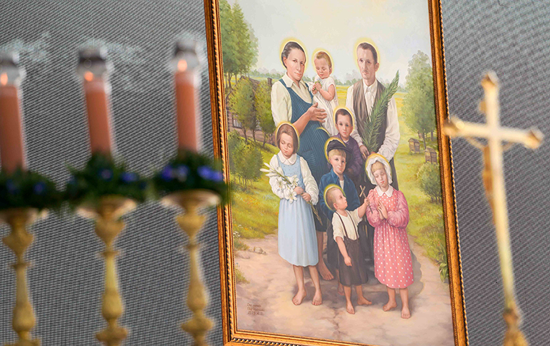 A portrait of Józef and Wiktoria Ulma, who is pregnant, and their six children hangs near the altar during their beatification Mass Sept. 10, 2023, in Markowa, Poland. Pope Francis prayed the family, killed for hiding Jews during World War II, would be an example to all Christians of goodness and service to those in need. (CNS photo/Justyna Galant)