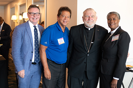 El Arzobispo Thomas Wenski en la Cumbre de Oportunidades de Miami: Contribuciones de los inmigrantes y soluciones bipartidistas posa con representantes de organizaciones católicas de la Arquidiócesis de Miami, desde la izquierda, Randy McGrorty, director ejecutivo de Catholic Legal Services; Peter Routsis-Arroyo, director ejecutivo de Catholic Charities y Myriam Mezadieu, directora de operaciones de Catholic Legal Services. La cumbre tuvo lugar el 22 de agosto de 2023.