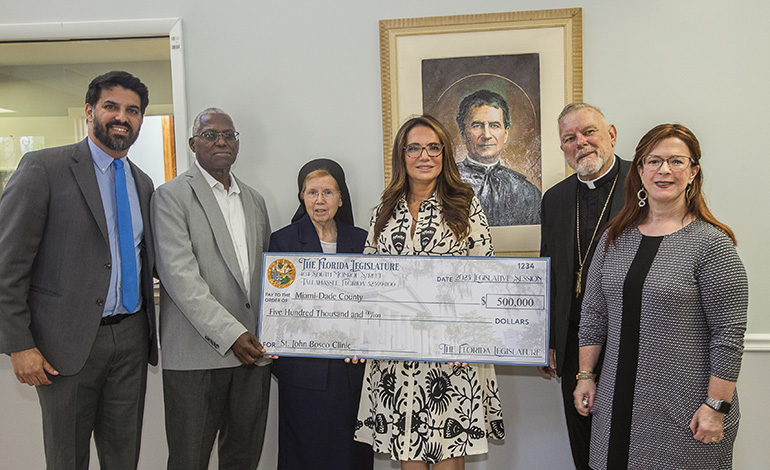 Florida State Sen. Ileana Garcia, center, presents a state appropriation of $ 500,000 to Archbishop Thomas Wenski and representatives of the St. John Bosco Clinic,  Sept. 5, 2023. From left: Anthony Pinto, executive director of the Sisters of St. Joseph (SSJ) Health Foundation; Jules Jones, Catholic Charities chief financial officer; Sister Elizabeth Worley, of the Sisters of St. Joseph, Archdiocese of Miami chancellor and for administration and a member of the board of the SSJ Health Foundation; Sen. Garcia; Archbishop Wenski; and Luz Gallardo, executive director of the clinic, which serves the uninsured and underserved and is a member of the Florida Association of Free and Charitable Clinics and the National Association of Free and Charitable Clinics.