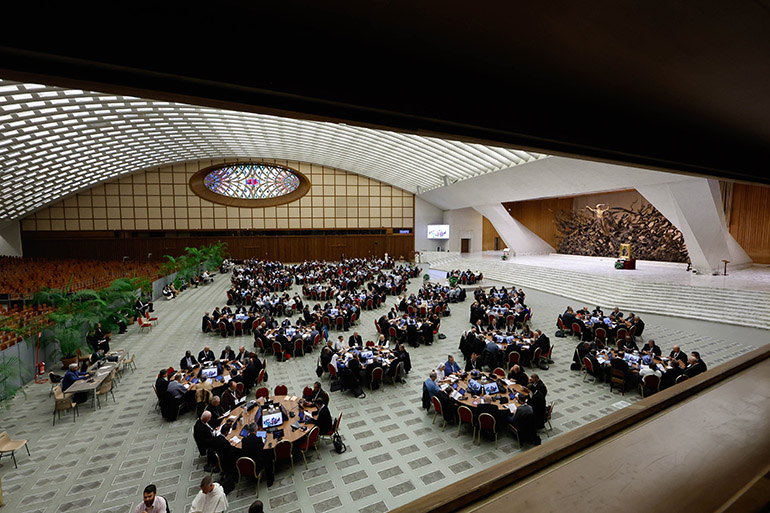 Pope Francis and members of the assembly of the Synod of Bishops pray before a working session in the Vatican's Paul VI Audience Hall Oct. 17, 2023. (CNS photo/Lola Gomez)