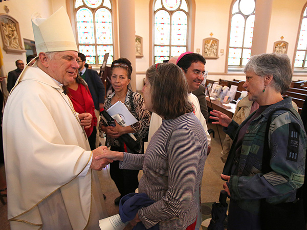 Miami Archbishop Thomas G. Wenski and Bishop Oscar Cantu, then of Las Cruces, New Mexico, now of San Jose, California, are pictured in a file photo greeting people after celebrating the "Mission for Migrants" Mass at St. Peter's Catholic Church on Capitol Hill in Washington. (OSV News photo/Bob Roller)