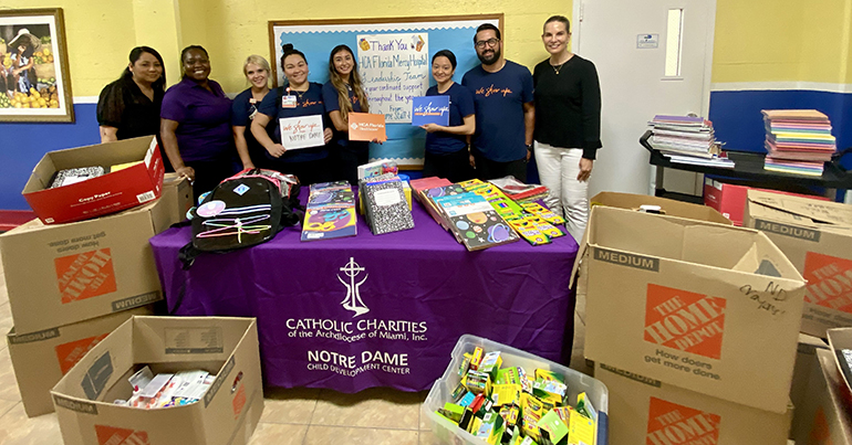 HCA Florida Mercy Hospital staff pose with some of the school supplies they collected and delivered to Catholic Charities Notre Dame Child Development Center in Miami for the 2023-24 school year.