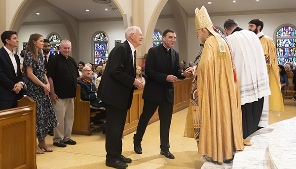 James Werle from St. Andrew in Coral Springs receives the Jubilaeum Cross from Archbishop Thomas Wenski during the Archdiocese of Miami's 65th anniversary vespers service, Oct. 22, 2023, at St. Mary Cathedral. He was accompanied by his pastor, Msgr. Michael Souckar.