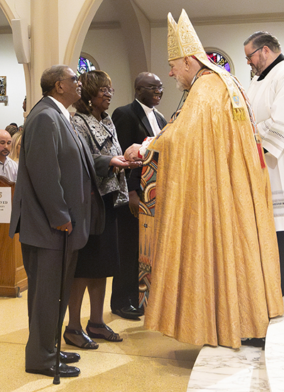 Charles and Constance Thornton, from St.Philip Neri, Miami Gardens, receive the Jubilaeum Cross from Archbishop Thomas Wenski during the Archdiocese of Miami's 65th anniversary vespers service, Oct. 22, 2023, at St. Mary Cathedral. They were accompanied by their pastor, Spiritan Father Fidelis Nwankwo.