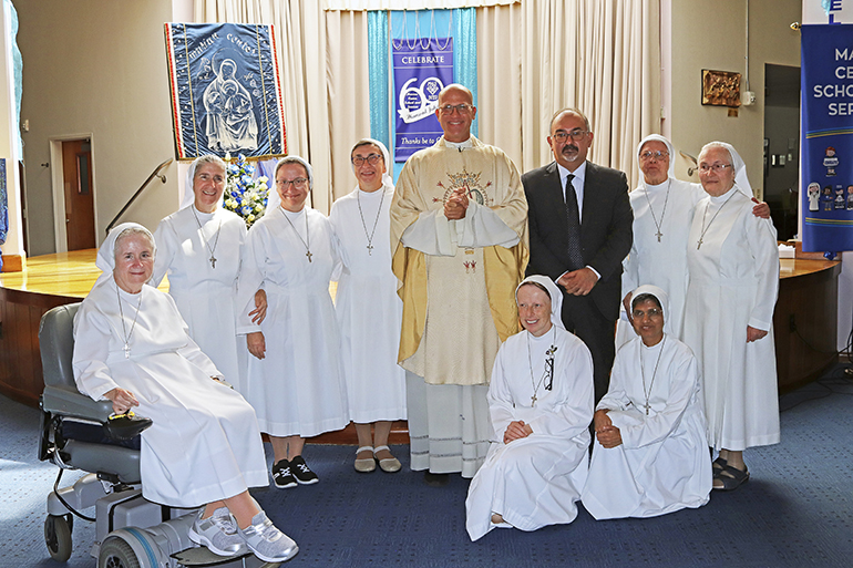 Posing after the Marian Center's 50th anniversary Mass, from left: Sister Mary Ellen Doyle (seated), Sister Filomena Mastrangelo, Sister Carla DeFeo, Sister Fausta Rondena, Father Christopher Marino, Sister Lidia Valli and Sister Mary Soshiyath (kneeling), Michele Mistò, Italian Consul General in Miami, Sister Enrica Donghi and Sister Germana Sala.