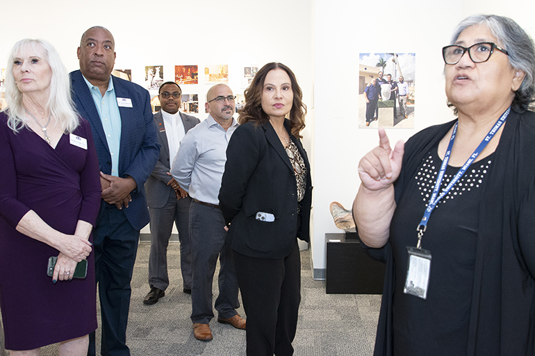 Museum coordinator Isabel Medina, right, speaks to guests at the opening of Roberto Perez Crespo's "The Hands of Christ" exhibit at St. Thomas University, Oct. 26, 2023. From left: Vice Provost Pamela Cingel, College of Business Dean David Edwards, Father Hilary Nwainya, director of theology programs, sculptor Perez Crespo and Michelle Johnson-Garcia, provost.