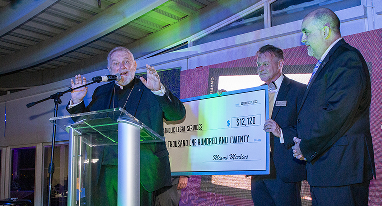 Alfredo Mesa, Marlins vice president of Public Affairs, far right, presents a $ 12,120 check from a Nicaraguan Heritage Celebration to Archbishop Thomas Wenski, left, and Catholic Legal Services' CEO Randolph McGrorty, center, at the gala marking the agency's 25th anniversary, Oct. 27, 2023, at the Hilton Doubletree Grand Bay in Miami.