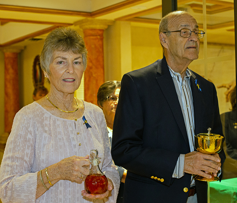 Karen Borgmann, parishioner since 1955, and Carlos Villalobos, parishioner since 1966, bring the offertory gifts of bread and wine during the Mass marking Blessed Trinity Parish's 70th anniversary, Nov. 4, 2023.
