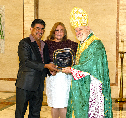Archbishop Thomas Wenski gives the One in Hope Award to Carlos and Elsie Caldera at the annual ThanksforGiving Mass, Nov. 18, 2023.