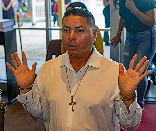 Marvin Mejia prays during the Mass at St. Michael the Archangel Church in Miami that was celebrated before the eucharistic procession, Nov. 25, 2023. Hundreds walked along Flagler Street, from St. Michael to St. John Bosco Church, singing hymns and accompanying the Blessed Sacrament.