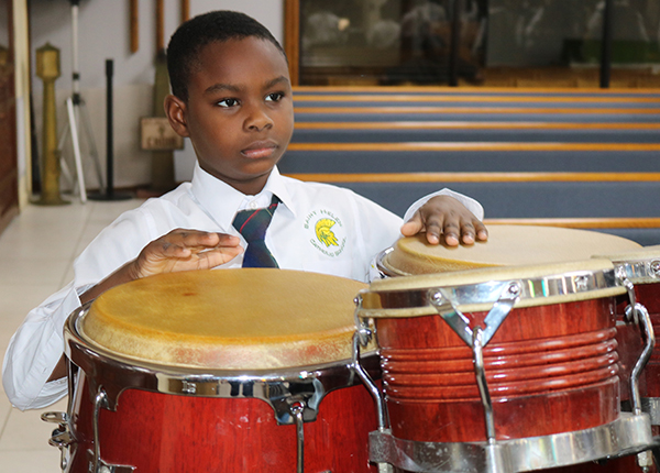 A student at St. Helen plays the conga drums during a school Mass at St. Helen Church in Lauderdale Lakes, Oct. 27, 2023. St. Helen School offers a music program as part of its many learning opportunities for young people.