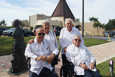 Desde la izquierda; Miguel y Teresa N&uacute;&ntilde;ez, Julio Estorino y Germ&aacute;n Rivas, integrantes de la Archicofrad&iacute;a de la Virgen de la Caridad que conocieron y trabajaron con Mons. Agust&iacute;n Rom&aacute;n posan cerca de su estatua de bronce, despu&eacute;s de la Misa que se celebr&oacute; por el 50 aniversario de la dedicaci&oacute;n de la Ermita de la Caridad de Miami, el 2 de diciembre de 2023.