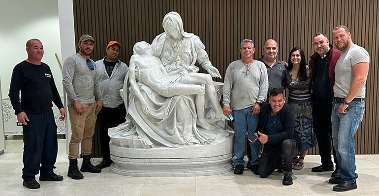 Father Israel Mago (second from right) and sculptor Nilda Comas pose with the team responsible for the relocation and installation of the replica of Michelangelo's La Pietà at Our Lady of Guadalupe Church in Doral on the evening of Nov. 1, All Saints Day. The gift was generously donated by James L. Case, III, and Elise A. Case, in loving memory of their father, James L. Case. The replica was made by Comas, a friend of Case, who commissioned the work.