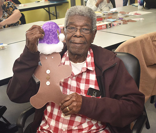 Egbert Francis, de 99 años, muestra su muñeco de jengibre en el centro de atención diurna para adultos de Wilton Manors. Dice que la gente suele decir que se parece al actor Morgan Freeman.
