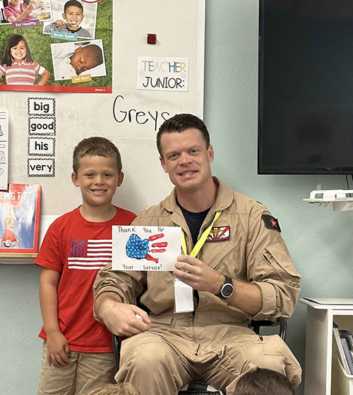 St. Mary Star of the Sea student Jack Rolletta poses with his father, Lt. Commander Mike Rolletta, during one of the military-themed activities offered by the Basilica School that earned it Florida's Purple Heart designation for its efforts to accommodate military families.