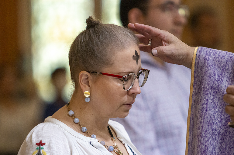 The faithful receive ashes at the Ash Wednesday Mass celebrated by Auxiliary Bishop Enrique Delgado, Feb. 22, 2023, in Gesu Church, Miami.