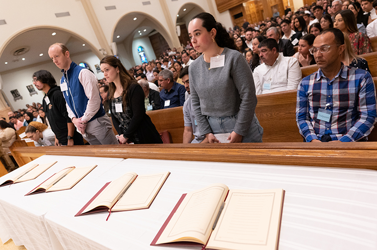 With the Book of the Elect in front of them, catechumens stand as Archbishop Thomas Wenski welcomes them as among the "elect" in the Catholic Church during the second of two Rite of Election ceremonies held at St. Mary Cathedral the Sunday after Ash Wednesday, Feb. 18, 2024.