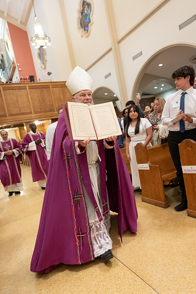 Archbishop Thomas Wenski shows the congregation the Book of the Elect as he welcomed catechumens who will soon join the Catholic Church during the second of two Rite of Election ceremonies held at St. Mary Cathedral the Sunday after Ash Wednesday, Feb. 18, 2024.
