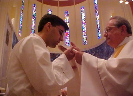 Father Manny Álvarez receives his priestly vestments from his spiritual director, Father Mario Vizcaíno, during his ordination Mass in 1993. Father Álvarez is currently pastor of Little Flower Church in Coral Gables.