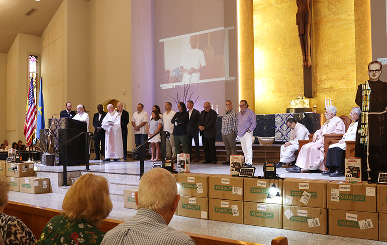 Julio Céspedes, representante de un grupo de ‘Los niños del P. Camiñas’, ahora abuelos, narra su salida de Cuba hacia España sin sus padres, durante la Misa del 10 de marzo de 2024, en la parroquia Corpus Christi, donde se reunieron colaboradores y donantes de la organización KèPoze, Inc., que ayuda a niños de Haití. Una muestra de Equipos de electricidad para teléfonos y ventiladores se entregaron durante la Eucaristía.